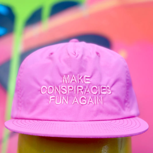 Pink cap with 'MAKE CONSPIRACIES FUN AGAIN' text 